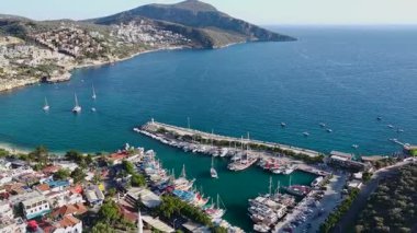 Mavi deniz kayalık yamaçlarda kurulmuş şehirle birleşir