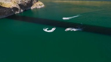 Mavi su, yüksek kayalar ve jet ski hareketi