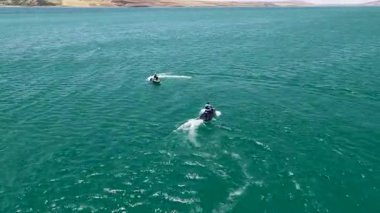 Sürücüler hareket eden bulutların altında manzaralı nehirde ilerlerler.