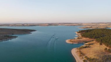 Nehir 4K 'da alacakaranlıkta tarım arazisinden akar. Parlak gökyüzü ve doğal detaylarla dolu huzurlu bir sahne.
