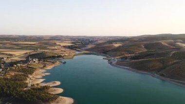 Nehir ve gökyüzü tarlaların üzerinde 4K 'da parlıyor. Günbatımı tonları sakin doğa ve tarım arazisi güzelliğini vurgular