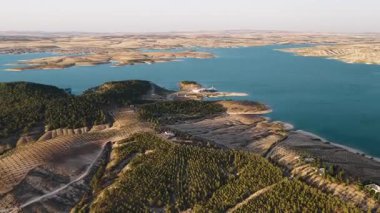 Gün batımında görülen uzun nehir ve mahsuller. Doğal kırsal çevreye sıcak 4K hava görüntüsü