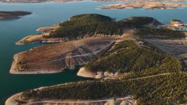 Nehirde altın ışık ve 4K 'de tarlalar. İnsansız hava aracı tarafından yakalanan kırsal bölgede doğal gün batımı parlıyor.