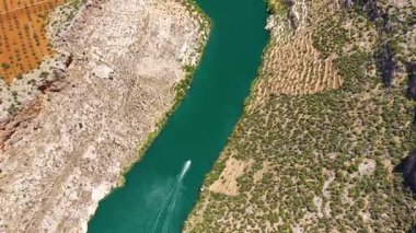 Jet skiler mavi gökyüzünün altındaki manzaralı uçurumları takip ediyor.