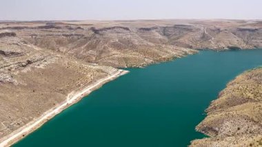 Nehir kenarındaki evlerin ve yüksek kayalıklar ve tepeler arasındaki sokakların insansız hava aracı görüntüleri..