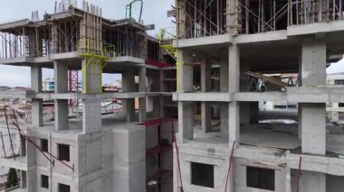 İnşaat ekibi beton dökerken, vinç de ağır destek yapılarını kaldırmaya yardım ediyor..