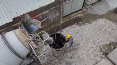 Vinç malzeme dağıtıyor, işçiler makineleri çalıştırıyor, ve site faaliyetlerle dolup taşıyor..