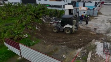 Traktör büyük miktarda toprağı hareket ettirir ve inşaat için düz ve istikrarlı bir yüzey oluşturur..