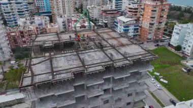 Beton dökme sürecini mühendislerin denetlediği yoğun bir inşaat sahası.