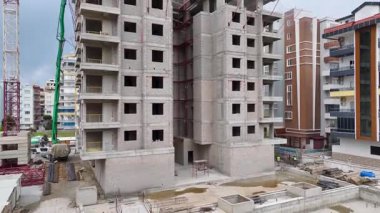 Vinçler, mühendisler ve inşaatçılar yapıyı genişletmek için birlikte çalışırlar..