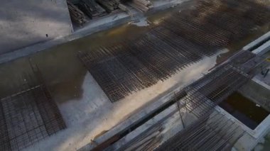 İşçiler metal ve çimentoyla uğraşırken mühendisler ilerlemeyi inceliyor.