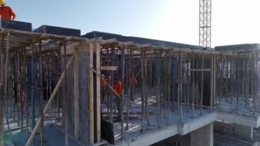 İnşaatçılar güneşli bir sabahta deniz kentini genişletmek için verimli çalışıyorlar..