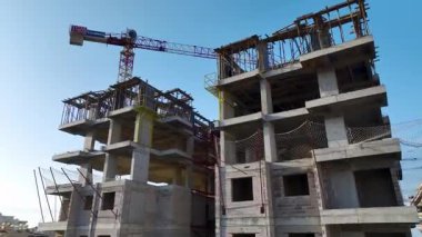 Sabah güneşi, deniz kıyısındaki küçük bir kasabada büyüyen bir gökdeleni vurguluyor..