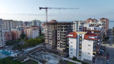 İnşaatçılar inşaatın son aşamasını şekillendirirken vinçler ve mühendisler yardım ediyor.