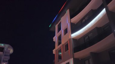 Karanlıktan sonra parlak ışıkları olan yeni emlak binaları.