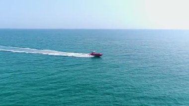 Güneşli bir günde kumlu plajı ve turkuaz denizi olan bir otel bölgesi..