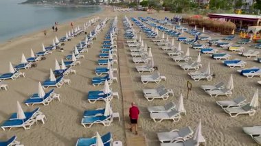 Sakin kumsalda güneşli yataklar ve hafif gün ışığı..