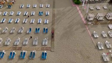 Şezlonglu altın kum ve sabahları sakin su.