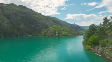 İnsanlar kanyon gölünün ortasında sörf tahtasında kürek çeker.