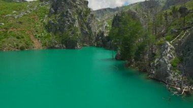 Arkadaşlar kanyon manzarasında kürek çekerler.