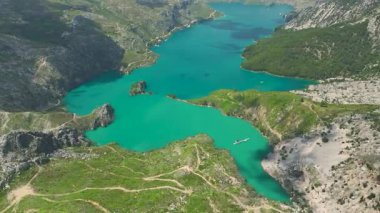 İnsansız hava aracı mermisi zümrüt suyun üzerindeki kanyon duvarlarını gösteriyor..