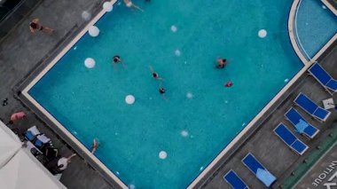 Turkuaz havuzlu villalar ve yüzen insanlar..