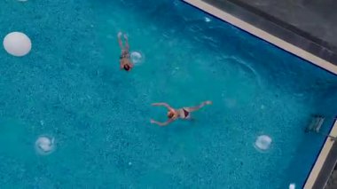 Turkuaz su havuzu ve bulutlu gökyüzü drone görüntüsü.