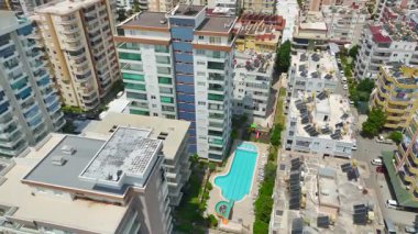 Turkuaz su ve bahçelerin yakınındaki tatil köyünün insansız hava aracı manzarası.