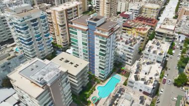 İnsansız hava aracı havuzlu, slaytlı ve aile arazili modern daireler gösteriyor.