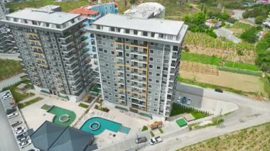 İnsansız hava aracı görüntüsü mavi Akdeniz yakınlarındaki şık evleri ön plana çıkarıyor.