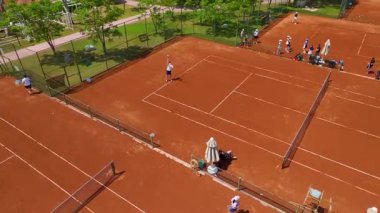 Üst görünüm, oyuncuların güneşli sahada hızlı hareket ettiğini gösteriyor.