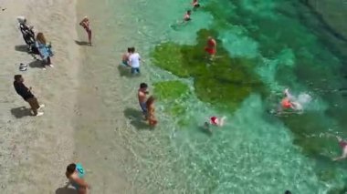 Açık mavi suyu olan deniz kıyısındaki tatil beldelerinin en üst görüntüsü.