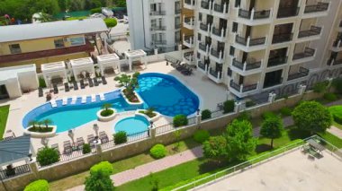 Kaydırak, havuz ve boş zamanı olan deniz kenarındaki konutların insansız hava aracı filmi.