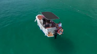 İnsansız hava aracı görüntüsü, altın kumlu sahil şeridinde bir tekne yakalıyor..