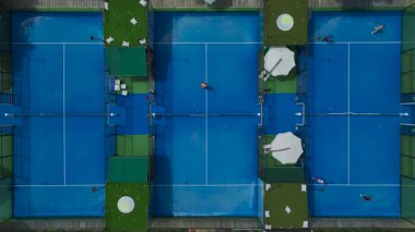 Palmiye ağaçları ile kortlarda yarışan oyuncuların yüksek görünümü.