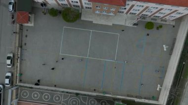 Hava filmi, spor sahası ve yolları olan bir avlu gösteriyor..