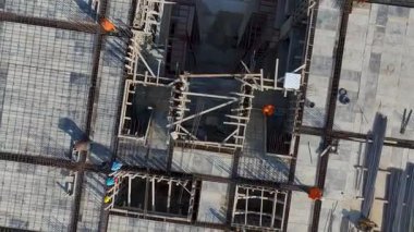 İnsansız hava aracı vinç kaldırma malzemeleri ve bölgede işçiler gösteriyor.