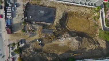 İnsansız hava aracı filminde vinç ve ekipler deniz kenarı inşaatında çalışıyor.