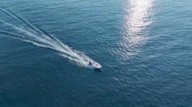 Suyun üzerinde sakince hareket eden teknenin hava görüntüleri..