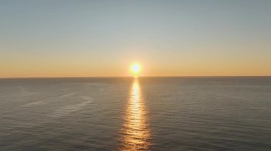 Hava alacakaranlıkta kumlu sahili yakalıyor.