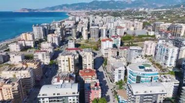 İnsansız hava aracı gün ışığında deniz kenarındaki evleri yakalıyor..