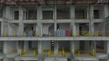 Vinçleri ve deniz kenarındaki binaları olan bir inşaat alanı.