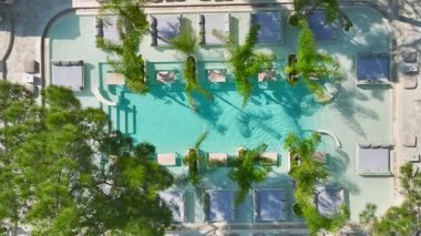 Drone turkuaz su ve modellerin rahatladığını gösteriyor..