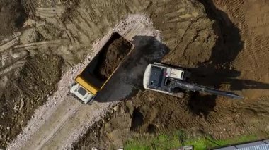 Kazıcı ıslak toprak yüzeyde çalışıyor.