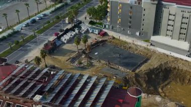 Drone, mühendislerin ve inşaatçıların vinçlerle yük kaldırdığını gösteriyor..