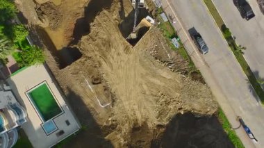 İşçilerin ve makinelerin yeni temellere hazırlandığı yoğun bir inşaat projesi.