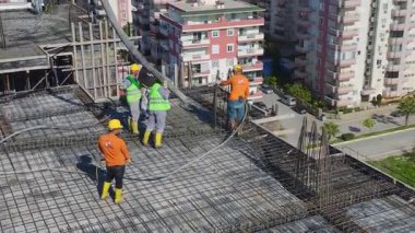 Mürettebat güçlendirilmiş çerçevelere çimento yayıyor.