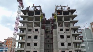 İşçiler çatıya çimento saçıyor.