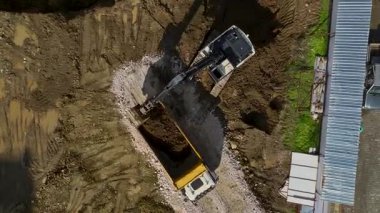 Kazıcı çamurlu bölgede toprağı hareket ettiriyor.