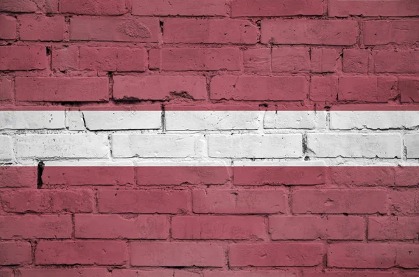 ラトビアの旗は古いレンガの壁に描かれています — ストック写真